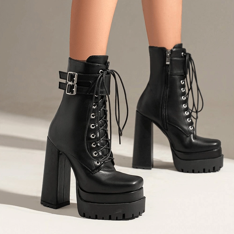 Model wearing black gothic platform ankle boots with side zipper and dual buckles, front low angle