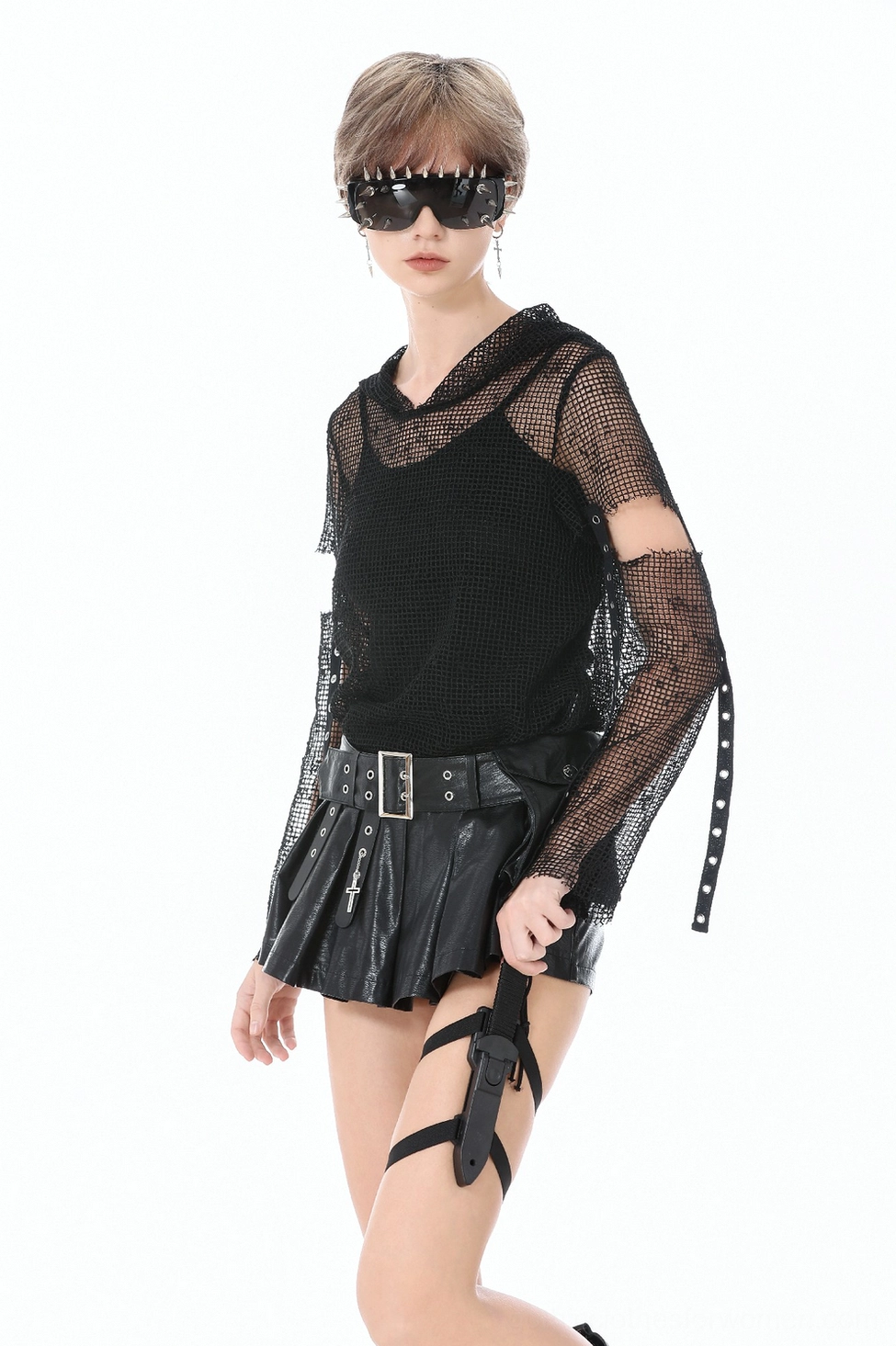 Full-body fashion shot of model wearing pleated black faux leather skort with gothic styling