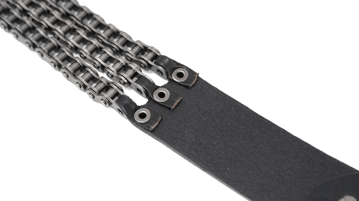 Close-up side view of two-row metal chain attached to leather strap with rivet fixed connection and gunmetal tone details