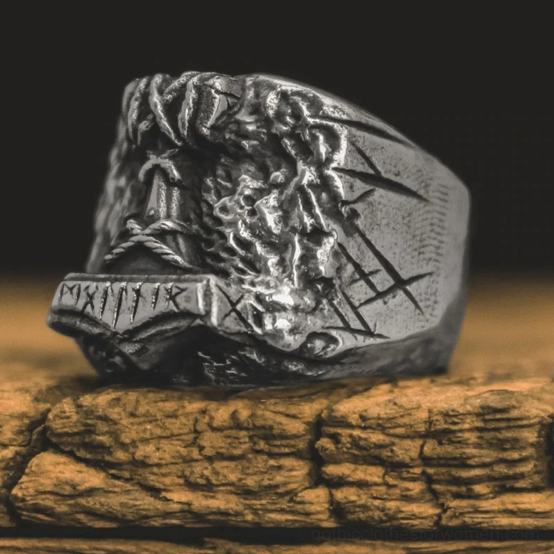 Norse amulet ring front side view on wooden surface showing matte silver finish and detailed carved rune engravings