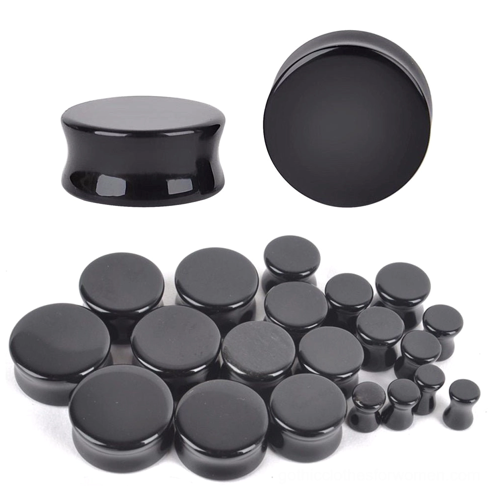 Multiple sizes of black obsidian ear plugs and gauges arranged overhead, showing the complete range of gothic flesh tunnels from 6mm to 25mm in matte black obsidian