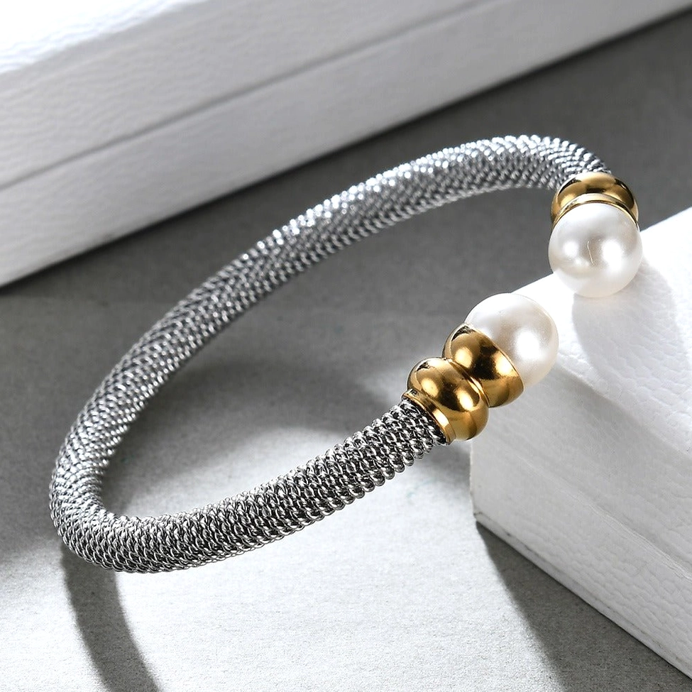 Side view of antique silver pearl cuff bracelet resting on white display box, detail perspective