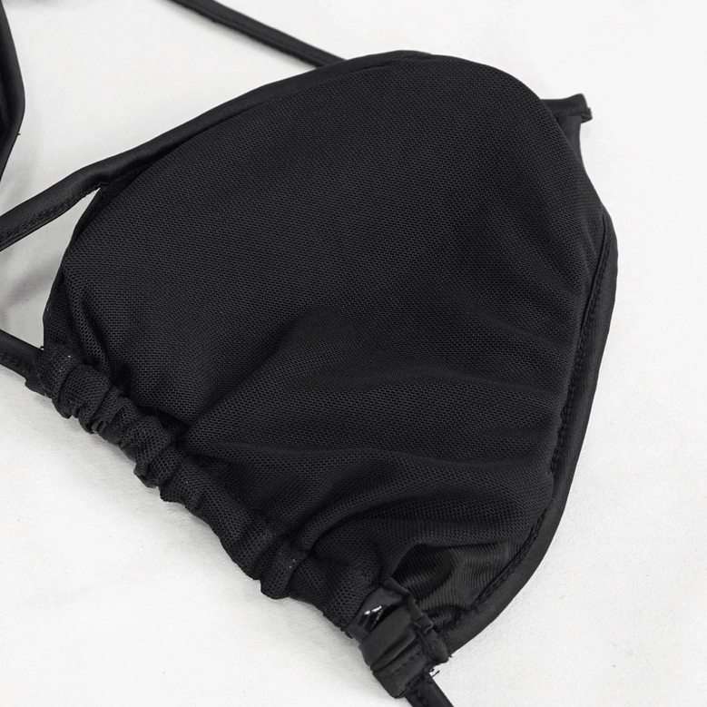 Close-up view of black pentagram bikini set showing glossy embossed five-pointed star pattern and premium strap stitching