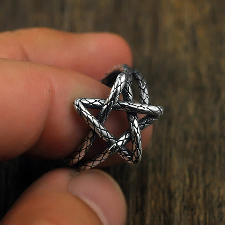 Close-up of held pentagram open ring revealing braided hollow star design and aged silver oxidized finish
