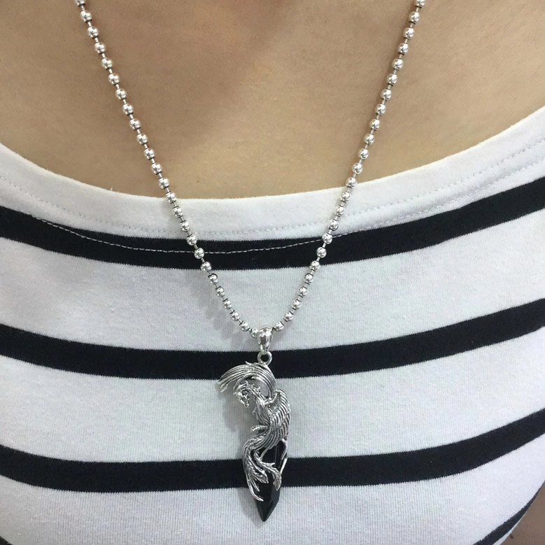 Gothic phoenix pendant necklace worn on body with silver bead chain and casual striped top layered styling