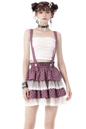 Pink gingham gothic suspender skirt front view with angel wing accents and lace trim on model