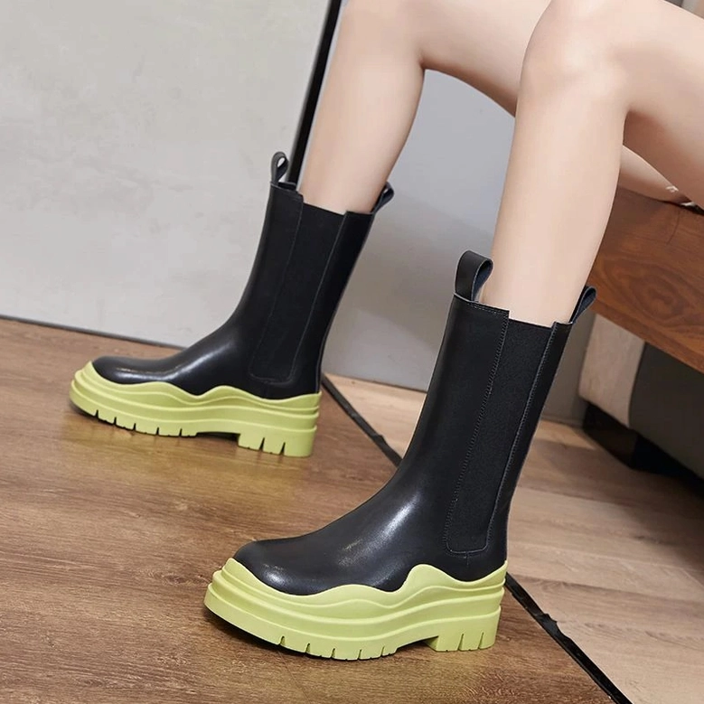 Black platform boots styling detail, showing elastic side panels, rounded toe shape, and premium leather construction quality
