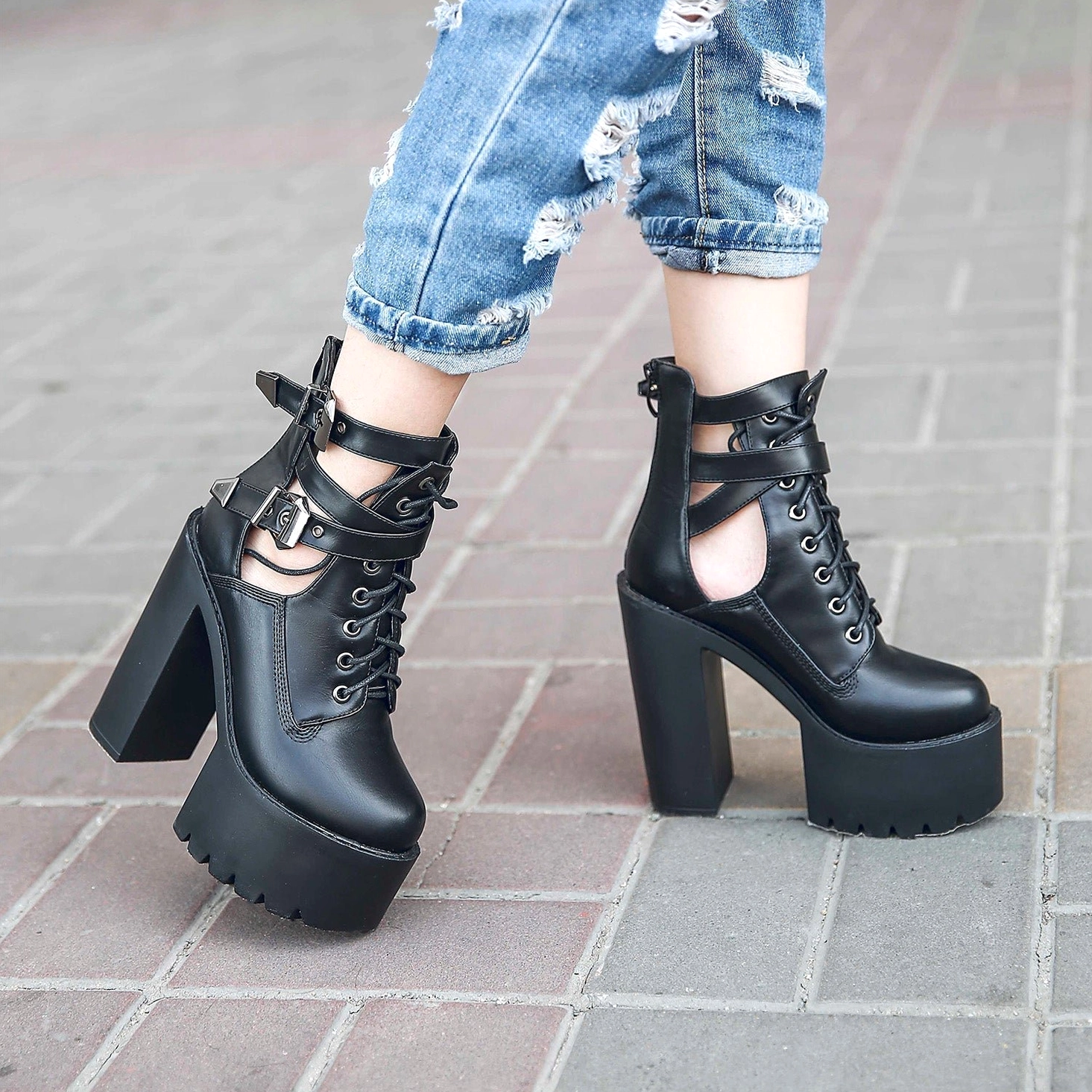Platform lace-up ankle boots with decorative metal buckle straps, showcasing the architectural design and alternative fashion aesthetic