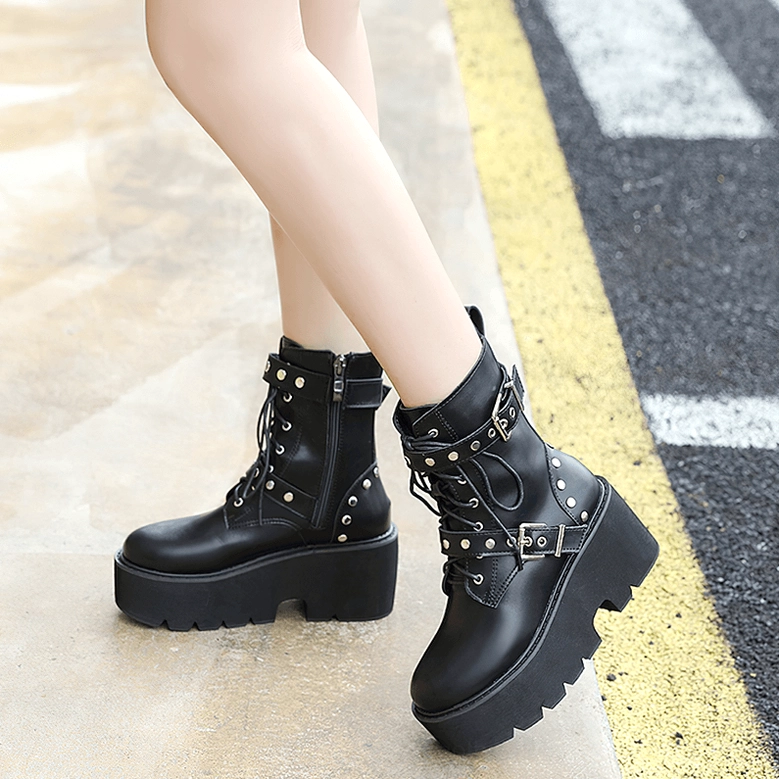 Black steampunk platform combat boots on model, side view showing chunky platform sole and rivet decorations outdoors