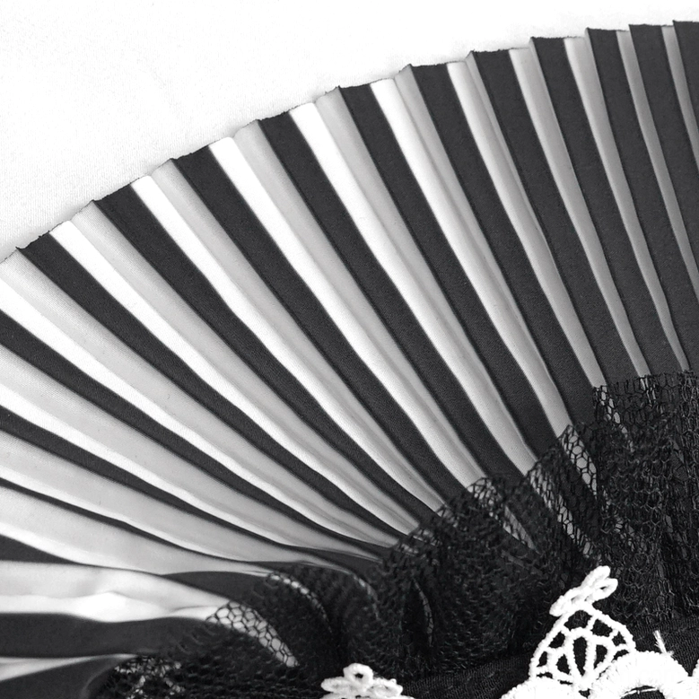 Detailed close-up of black and white striped pleated fabric with mesh lace edge on gothic neckwear