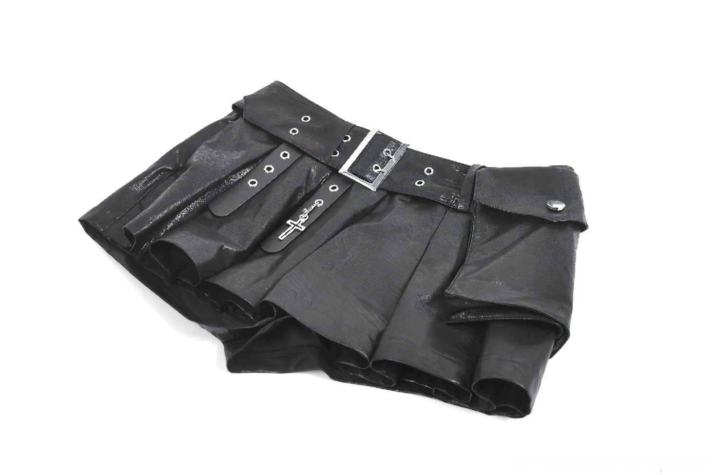 Oblique angle flat lay of pleated faux leather skort highlighting layered pleats and metal buckle belt hardware