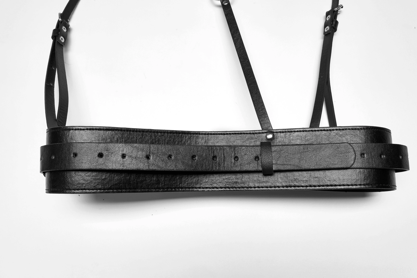 Black punk leather harness flat lay top-down view, strap adjustment holes and full layout, gothic body harness product overview