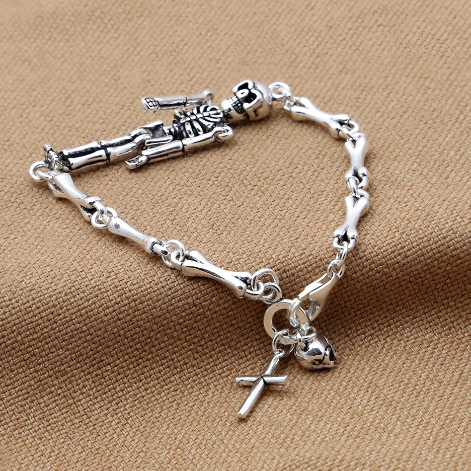 Vintage-inspired skeleton punk bracelet with bone link chain and decorative bead charms displayed on brown fabric background