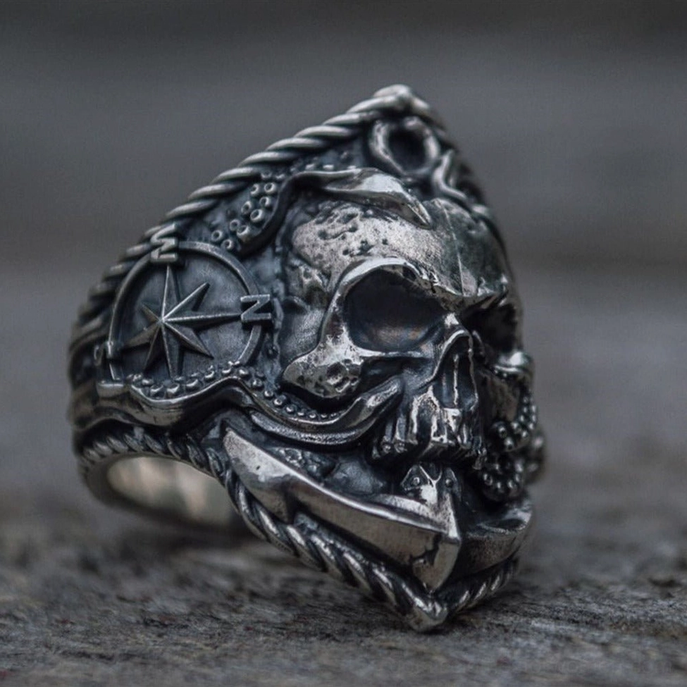 Punk skull anchor ring side view combining compass, octopus tentacles and anchor elements on rough stone surface