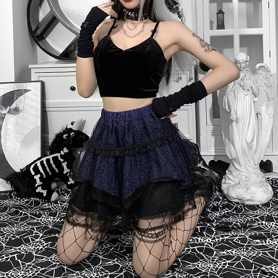 Kneeling model showcasing purple leopard print gothic skirt with black lace trim and fishnet stockings detail