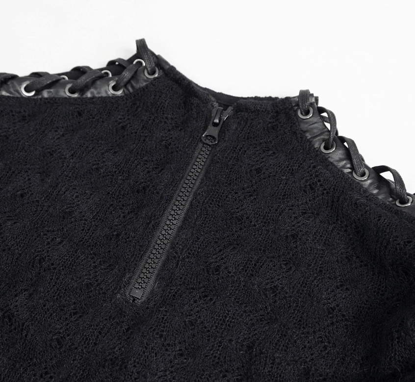 Detail shot of black quilted cropped top showing chain embellishments and quilted knit fabric texture