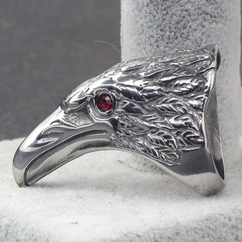 Stainless steel raven ring left side view on jewelry display stand with polished surface and feather engravings