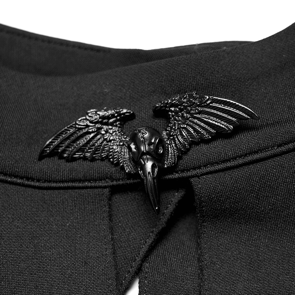 Detailed close-up of winged raven skull brooch and black metal hardware