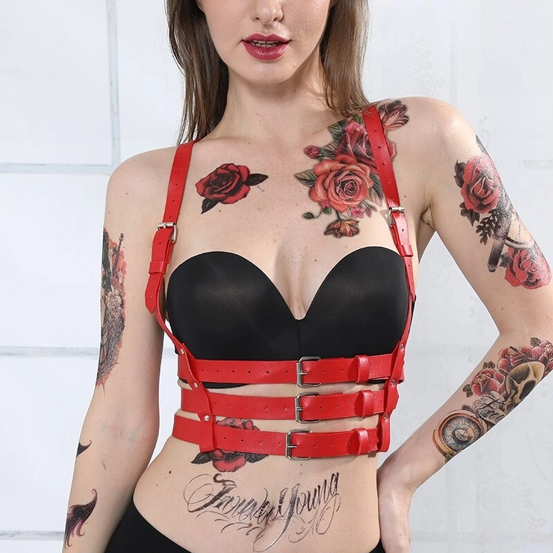 Red leather garter harness detail view of thigh suspender bow accents and adjustable strap configuration