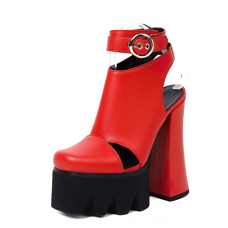 Red gothic platform heels with black scalloped sole and ankle buckle strap fastening