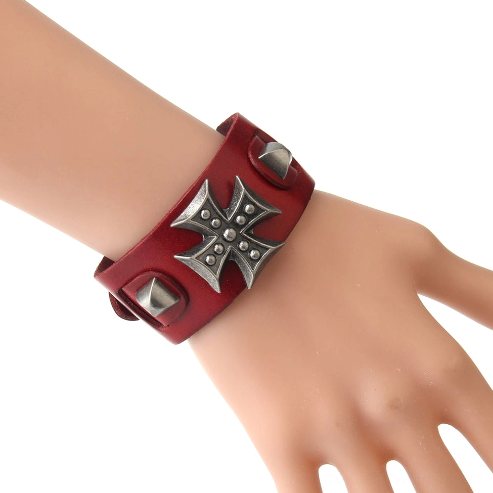 Red leather gothic cross wrap bracelet worn on wrist, showing adjustable toggle clasp and cone stud details