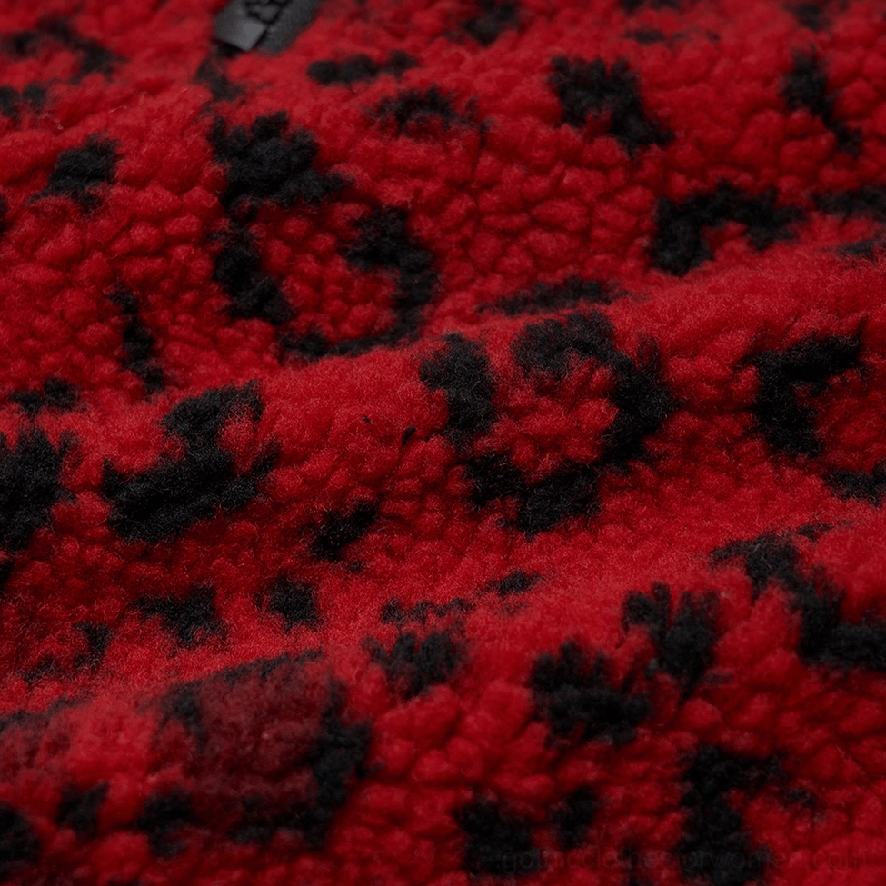 Texture close-up of red base with black leopard spots fuzzy fleece fabric on gothic mini skirt
