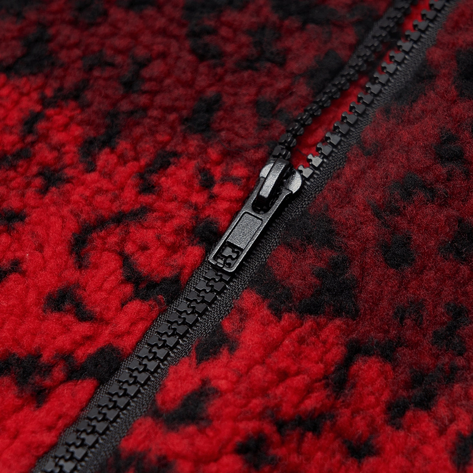 Macro photography of exposed black metal zipper closure on red leopard fleece gothic mini skirt