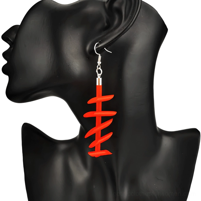 Red twisted spike rubber dangle earrings gothic punk jewelry worn on black mannequin ear model close-up right side