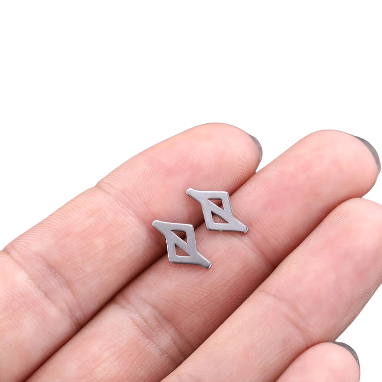 Rhombus hollow diamond gothic rune stud earring held in fingertips, polished silver stainless steel with geometric precision