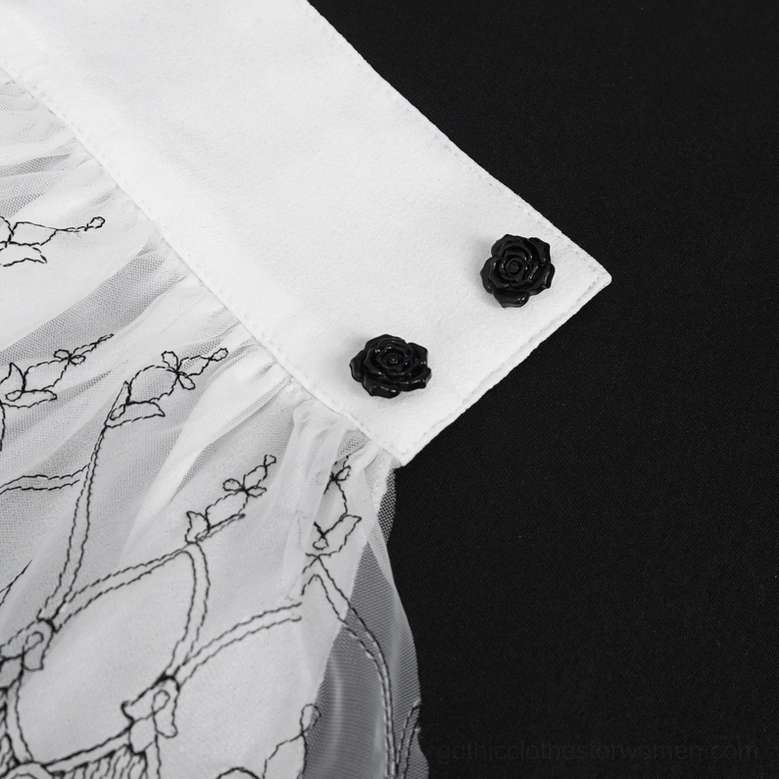 Close-up detail of black rose snap buttons on Victorian lace glove cuff with vine embroidery pattern