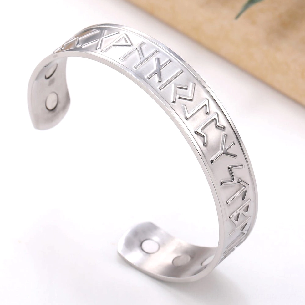 Gothic nordic rune stainless steel bracelet oblique angle wooden background rustic aesthetic