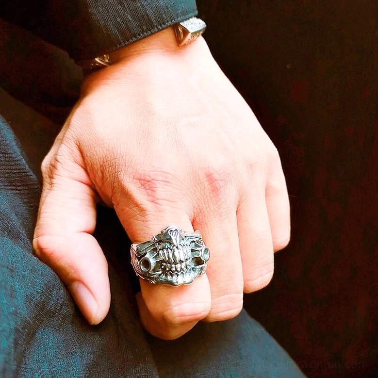 Detailed sculptural gas mask ring on formal sleeve showcasing intricate crafted texture