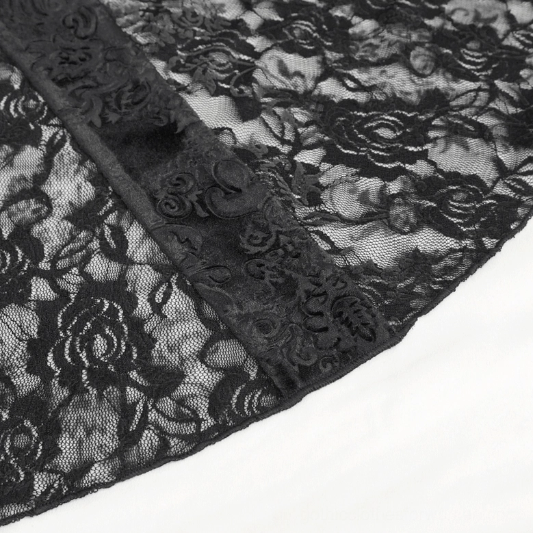 Close-up sheer floral lace pattern on flared leg of black damask gothic pants with velvet trim