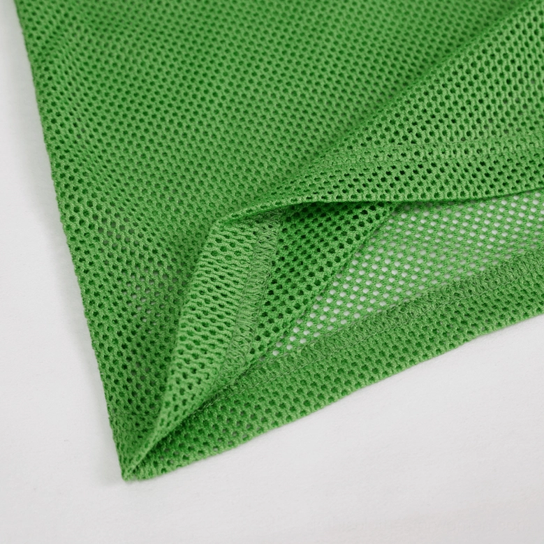Folded emerald mesh fabric showing double-layer weave and transparent see-through mesh construction