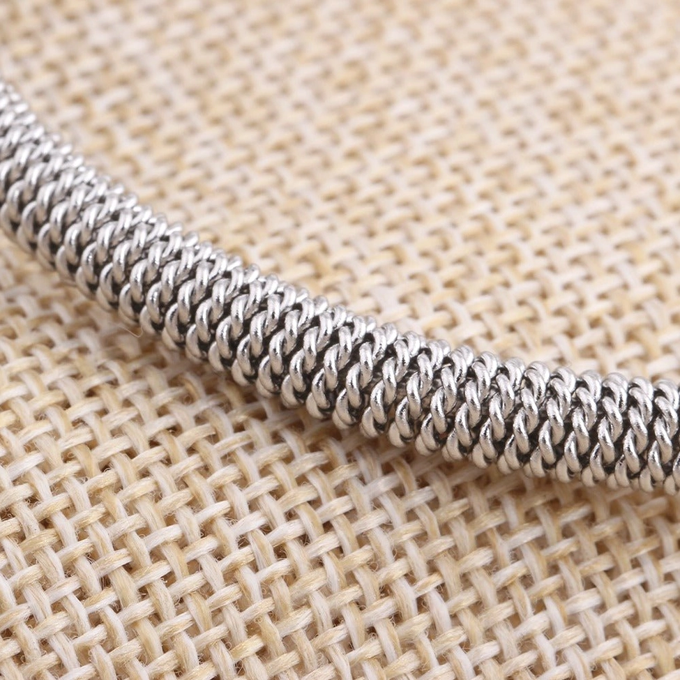Light silver woven stainless steel pearl bracelet with dual pearl accents and gold hardware detailing