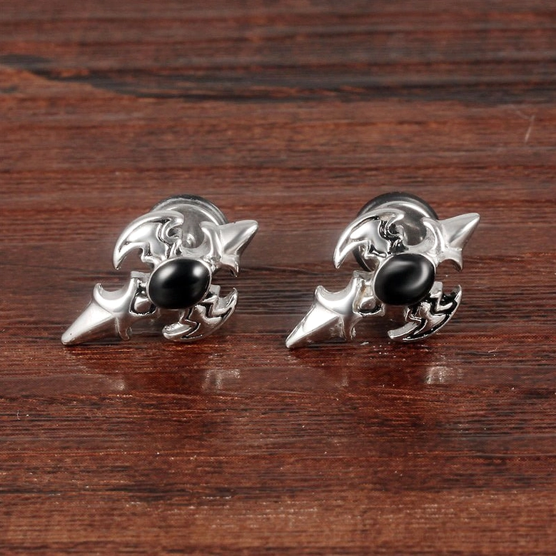 Silver gothic cross stud earrings on wooden surface background - warm product display photography