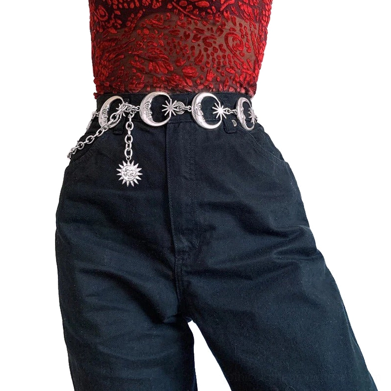 Silver crescent moon and sun charm chain belt worn at high waist on female model, front view with celestial gothic aesthetic