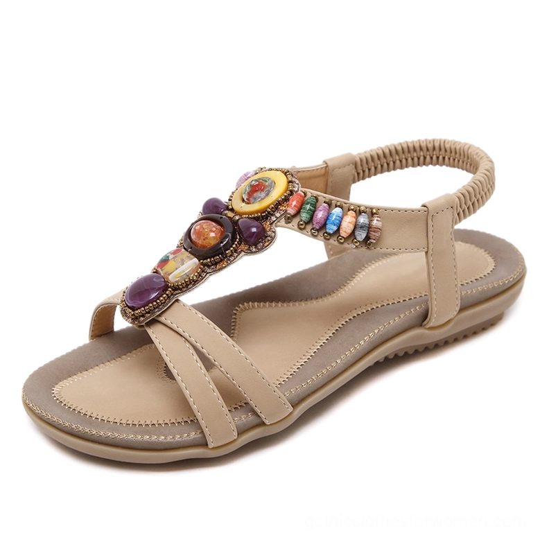 Single beige beaded gothic sandal showing colorful bead detailing and flat rubber sole, front oblique view