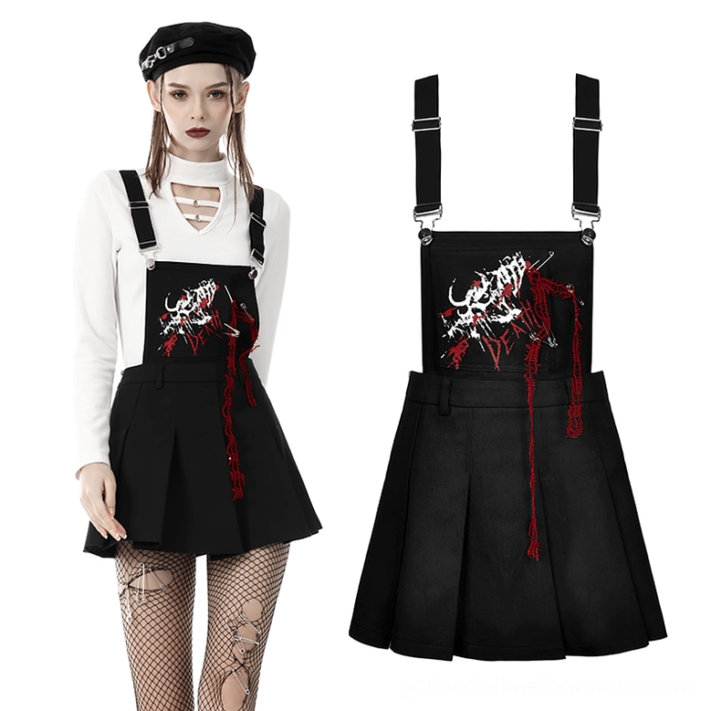 Black skeleton pinafore dress full view styled with fishnet tights, beret, and layered gothic top