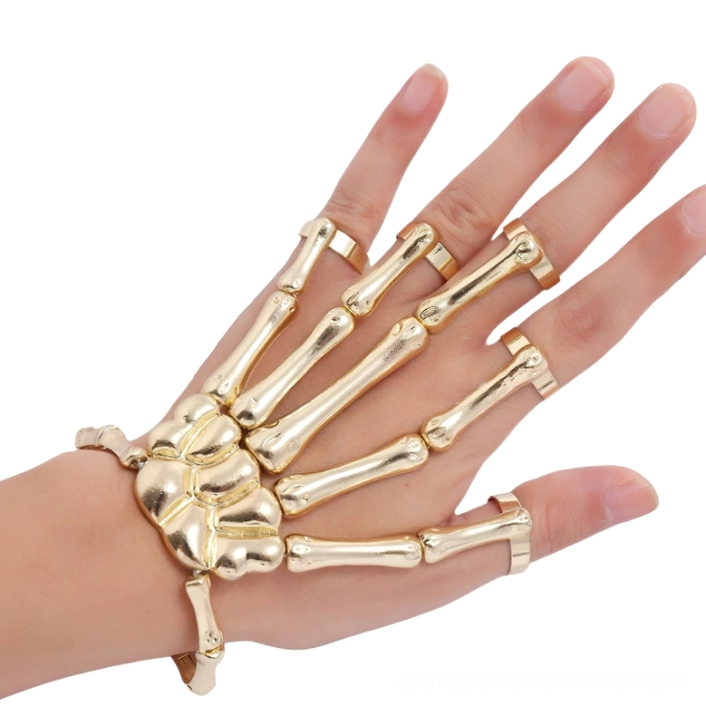 Gold-toned skeleton hand slave bracelet front close-up display with matching finger rings on model hand