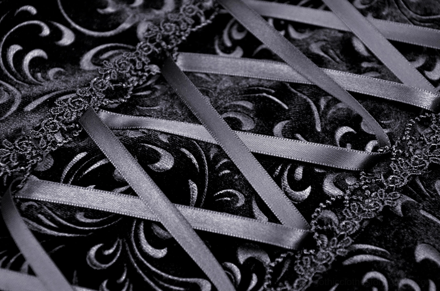 Fishtail skirt back lace-up detail featuring satin ribbons, embroidered velvet base, and decorative lace trim