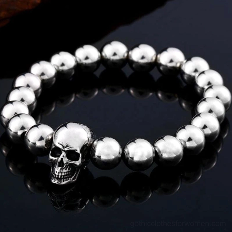 Stainless steel skull beaded bracelet detail shot - 3D skull charm against black reflective background