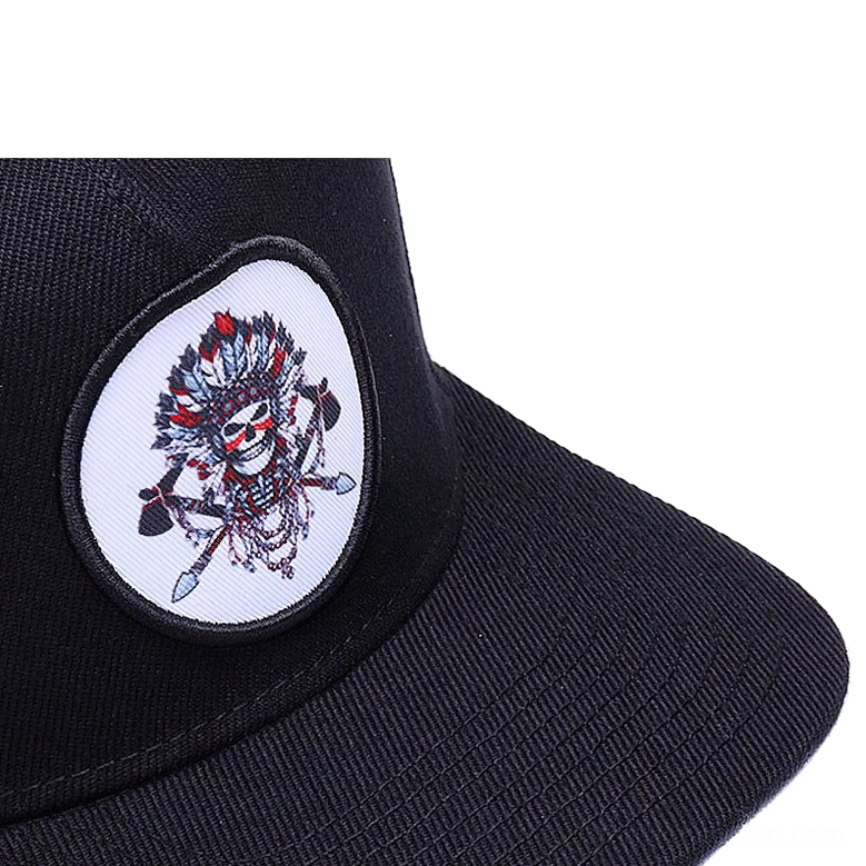 Black twill fabric and embroidered skull patch close-up - snapback cap brim detail