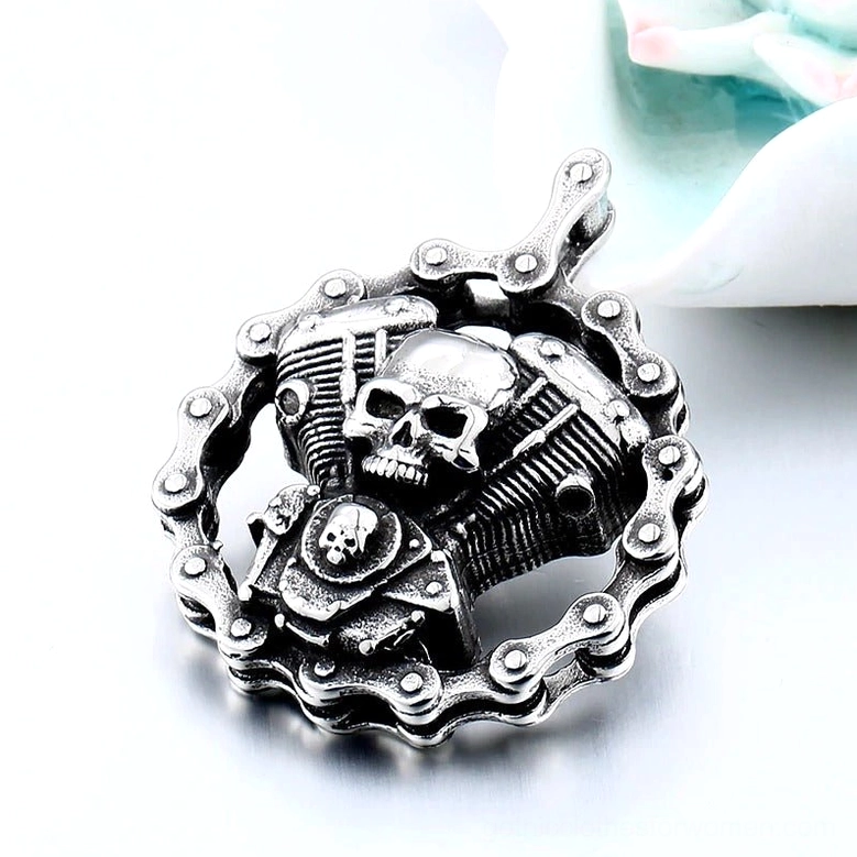 Oblique front view of skull engine gothic pendant - twin engine with dual skull details and intricate mechanical stainless steel design