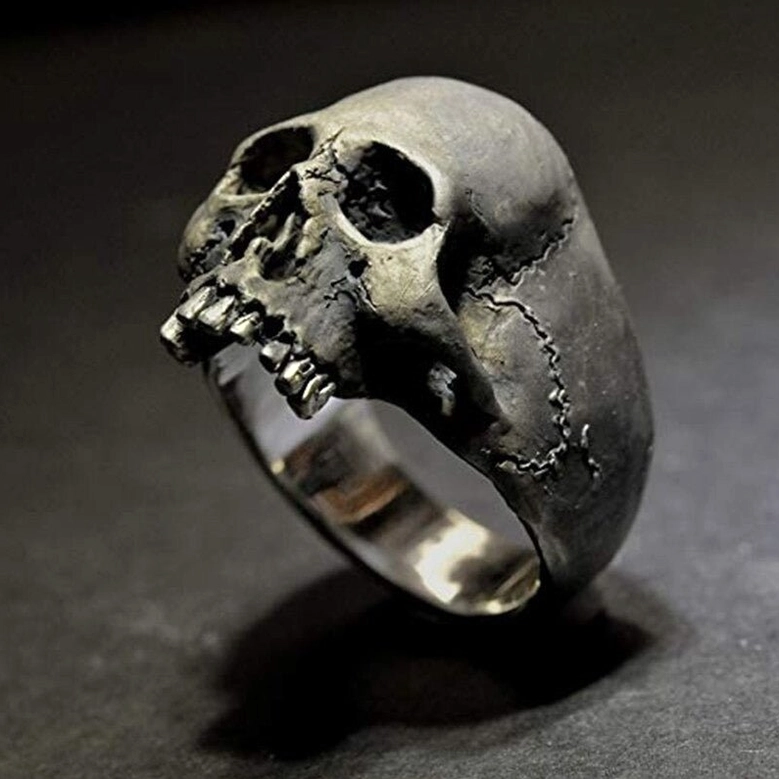 Blackened silver skull ring with stitched crack details, right front oblique angle on dark studio background