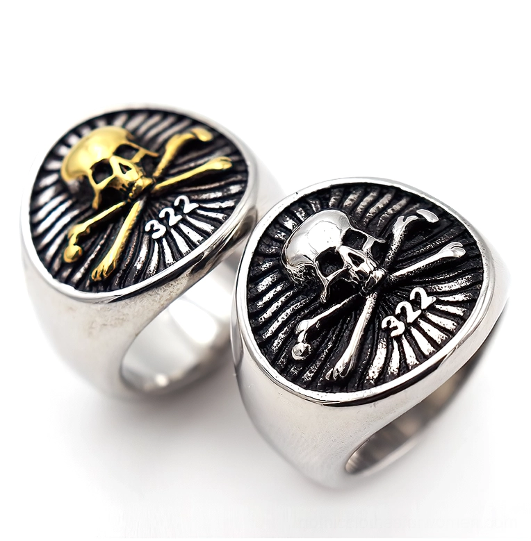 Pair of skull pirate signet rings in gold and silver stainless steel, top-down flat lay comparison