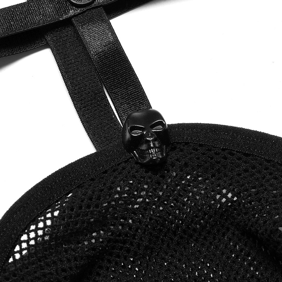 Macro close-up of skull-shaped metal rivet attachment on black fishnet fabric, showing rivet and mesh detail