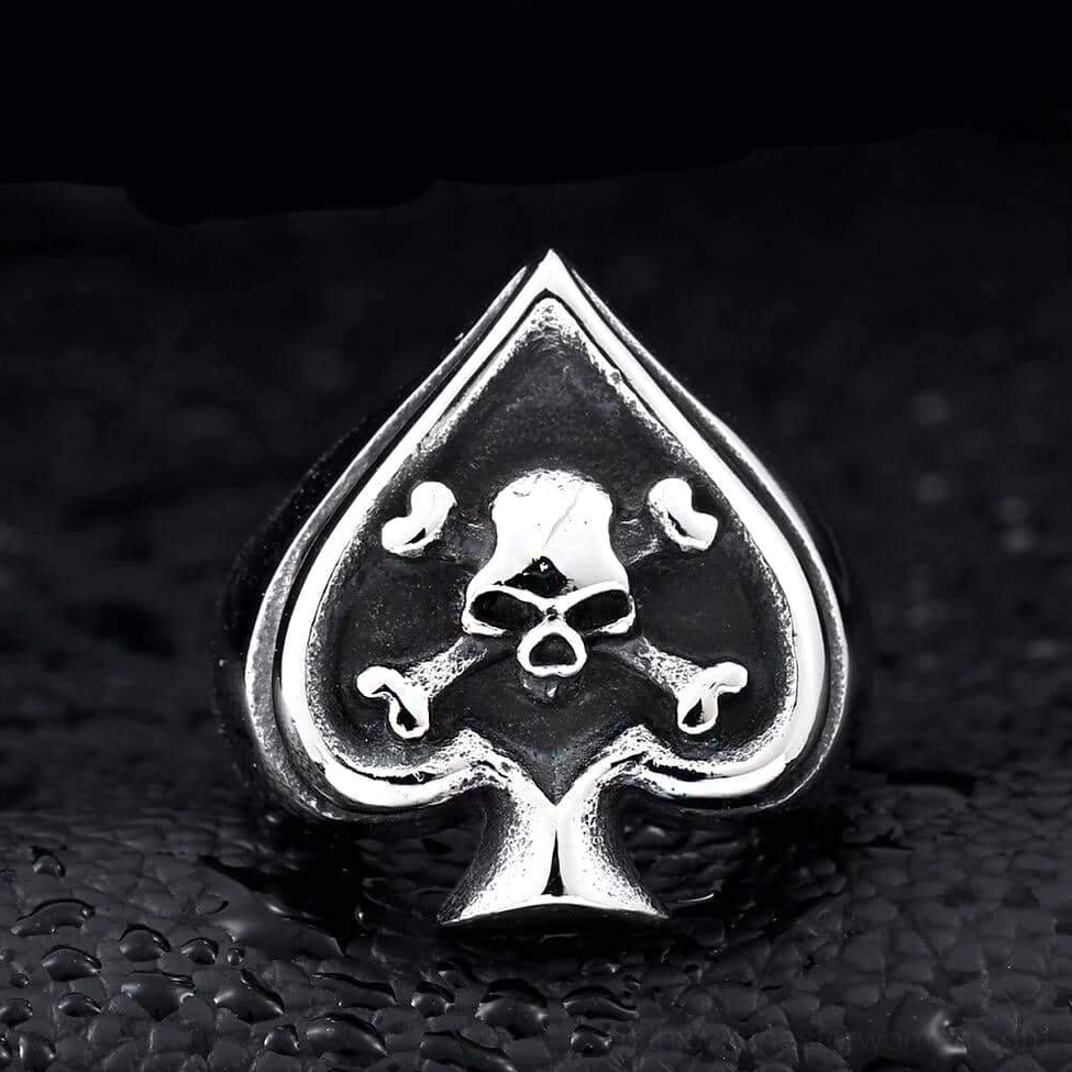 Symmetrical spade skull crossbones gothic signet ring front flat detail leather background