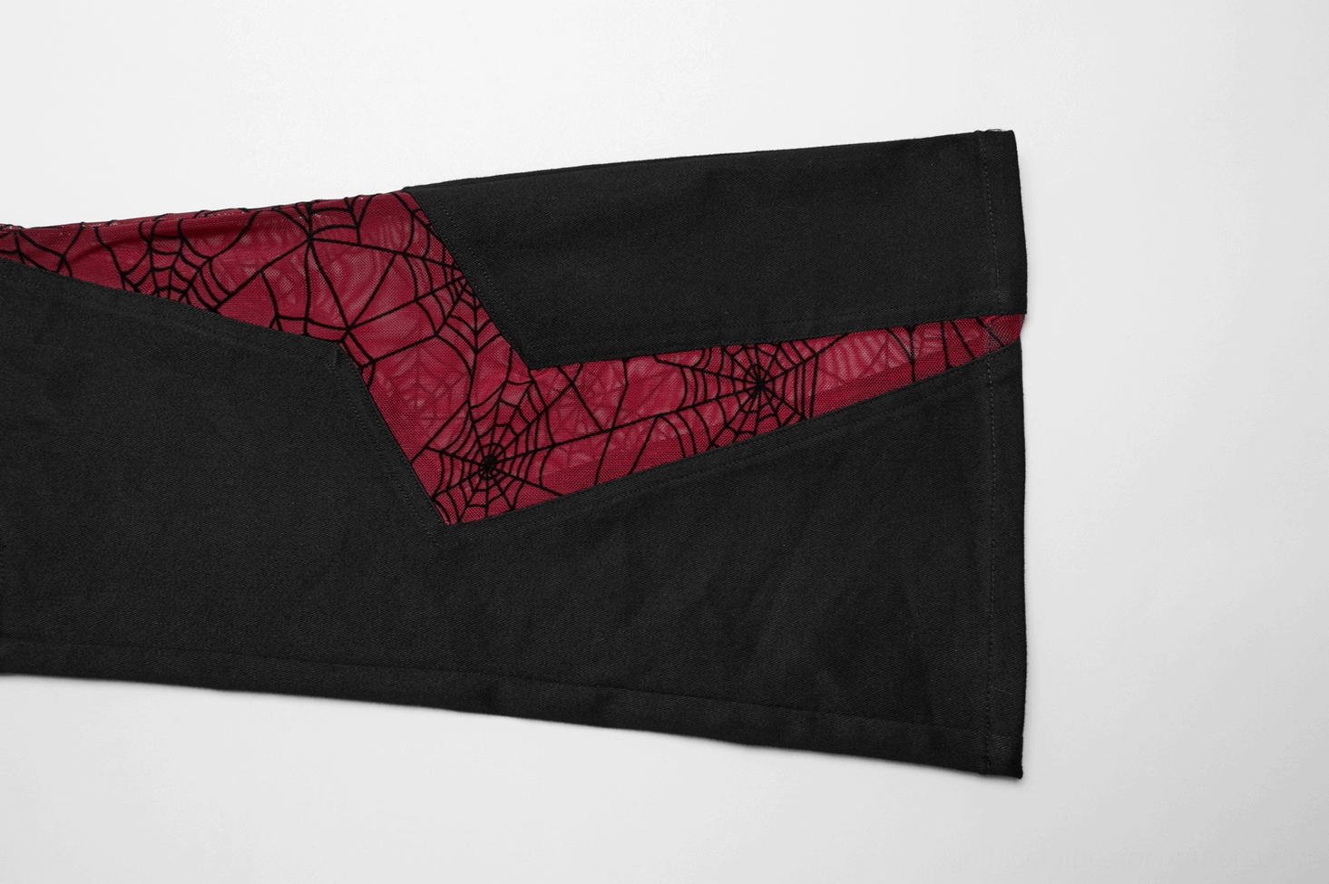Close up of black leg panel with red spiderweb mesh angular geometric design
