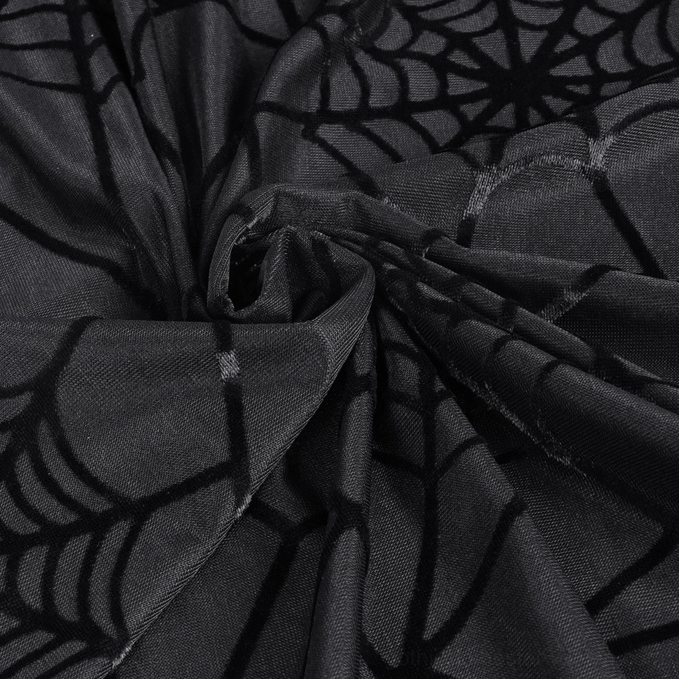 Draped detail of black sheer spiderweb pants - mesh fabric movement and velvet pattern definition